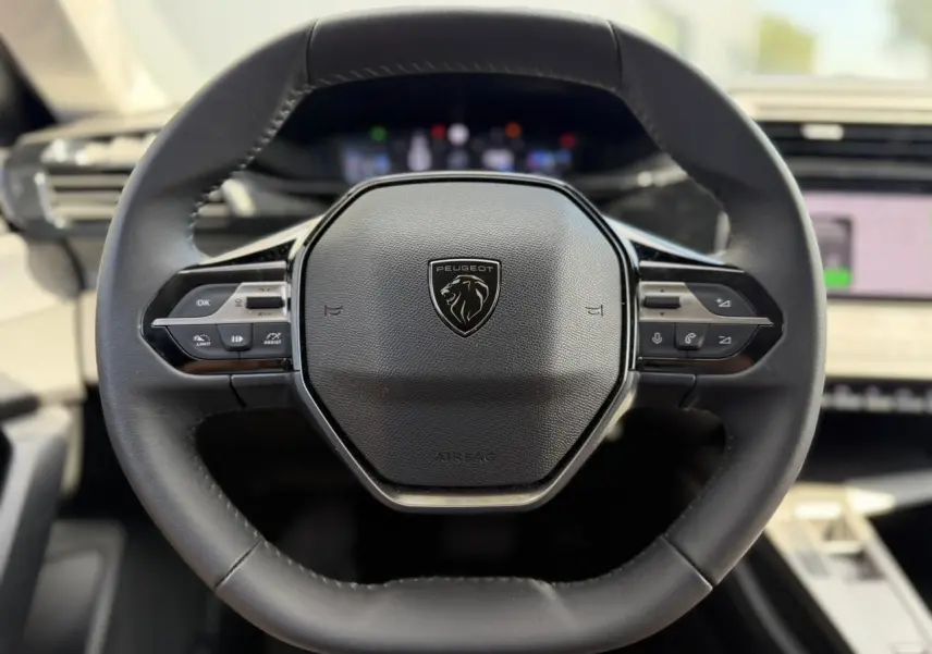 Volant cuir noir Peugeot 308 SW 2025 vu de face avec commandes intégrées et logo lion central.