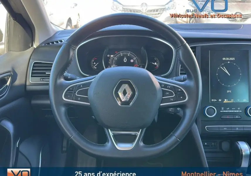 Vue frontale du volant cuir et du tableau de bord numérique de la Renault Mégane IV beige avec écran tactile et commandes intégrées.