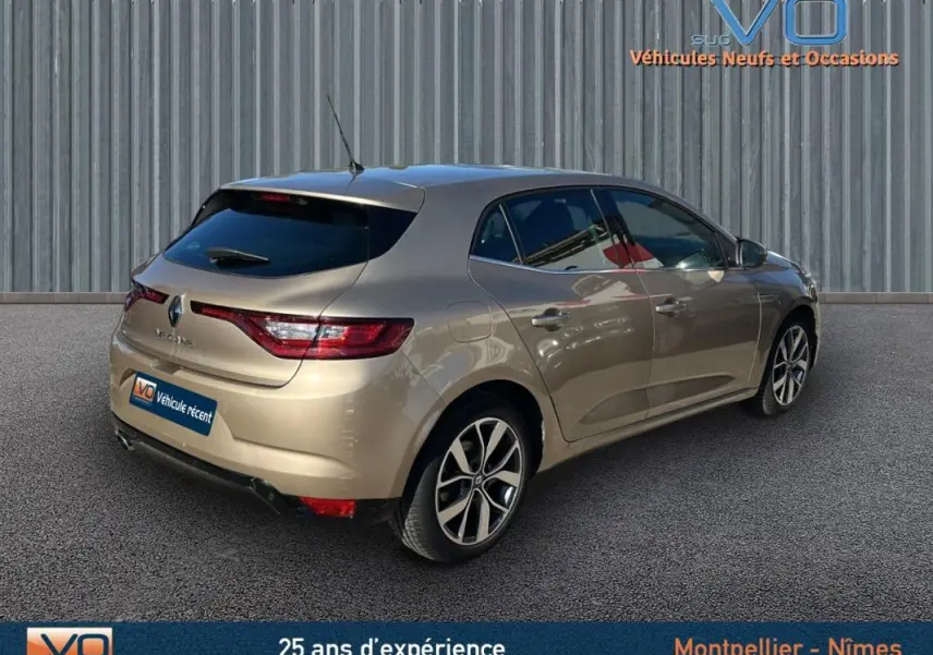 Vue 3/4 arrière droite d'une Renault Mégane IV beige, berline compacte avec feux arrière LED et jantes alliage.