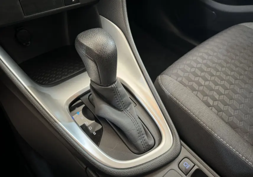 Le levier de boîte automatique en cuir noir et console centrale de la Toyota Yaris hybride 2022 vue de dessus côté siège passager.