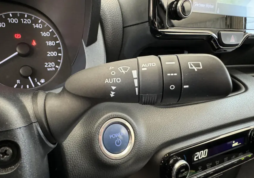 Gros plan sur la commande d’essuie-glace et bouton Power du tableau de bord noir de la Toyota Yaris hybride 2022.