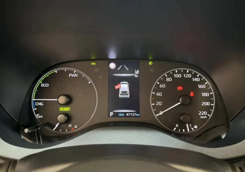 Tableau de bord de Toyota Yaris hybride 2022 montrant compteurs et écran central avec alertes et vitesse zéro km/h.