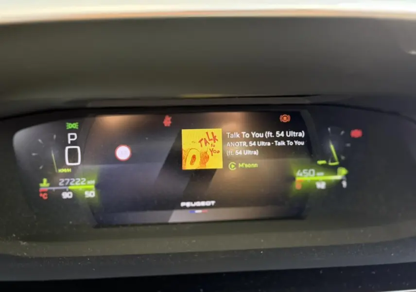 Affichage numérique du combiné Peugeot i-Cockpit 3D de la 308 SW, avec informations de conduite et média en cours.