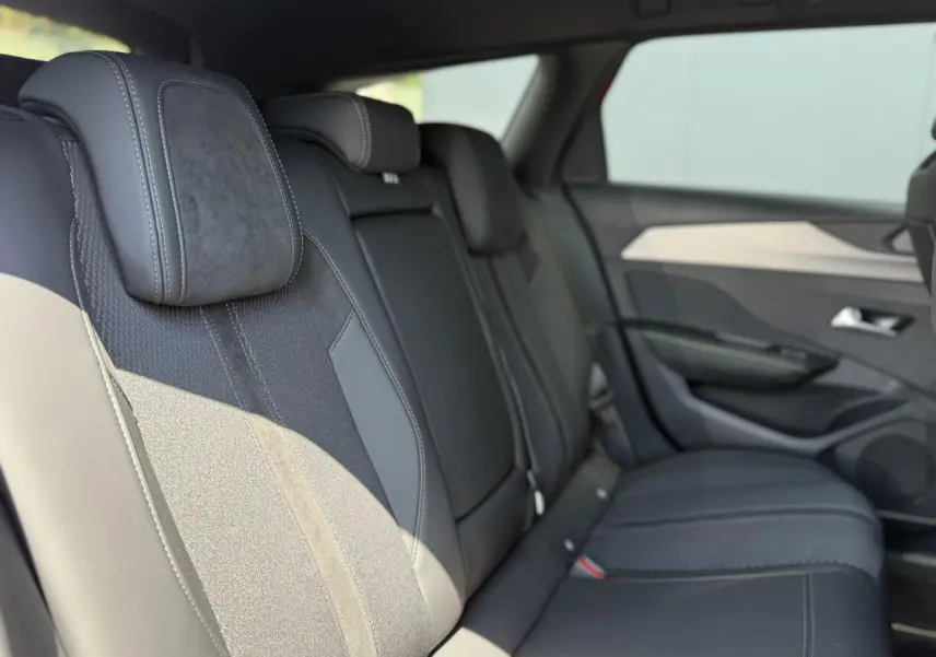Vue latérale droite des sièges arrière en sellerie tri matières noire de la Peugeot 308 SW 2024.