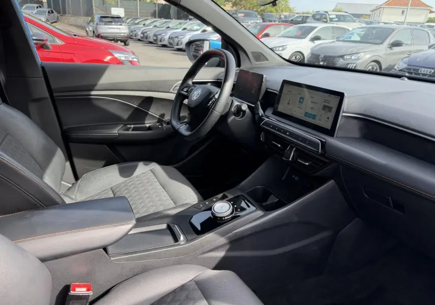 Intérieur côté conducteur du MG3 1.5 Hybrid+ 2025, avec sièges noir simili-cuir, volant cuir multifonction et écran tactile.