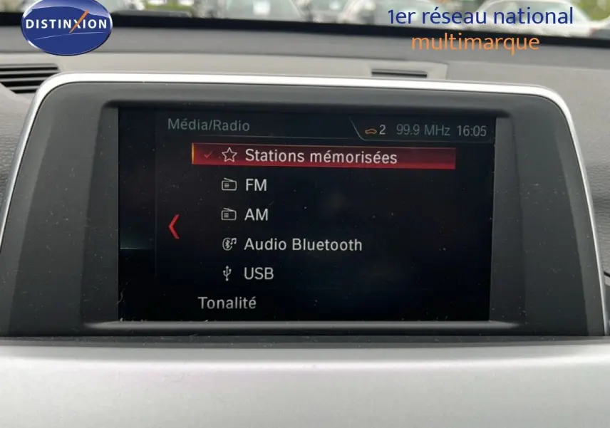 Écran multimédia de BMW X1 18i 2018 affichant les options radio FM, AM, Bluetooth et USB dans un intérieur gris.