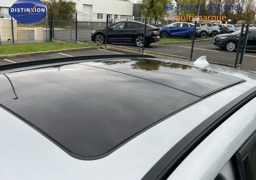 Toit ouvrant panoramique en verre sur BMW X1 gris argent métal, vue en léger plongé depuis l'arrière droit.