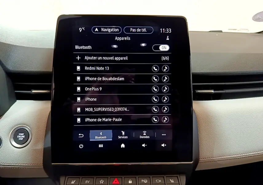 Gros plan sur l'écran tactile central et le tableau de bord beige de la Renault Clio Initiale Paris E-TECH 140 2021.