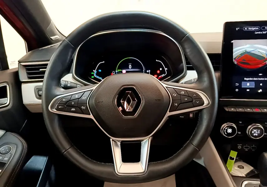 Vue intérieure centrée sur le volant cuir noir et le tableau de bord numérique de la Renault Clio Initiale Paris E-TECH 2021.