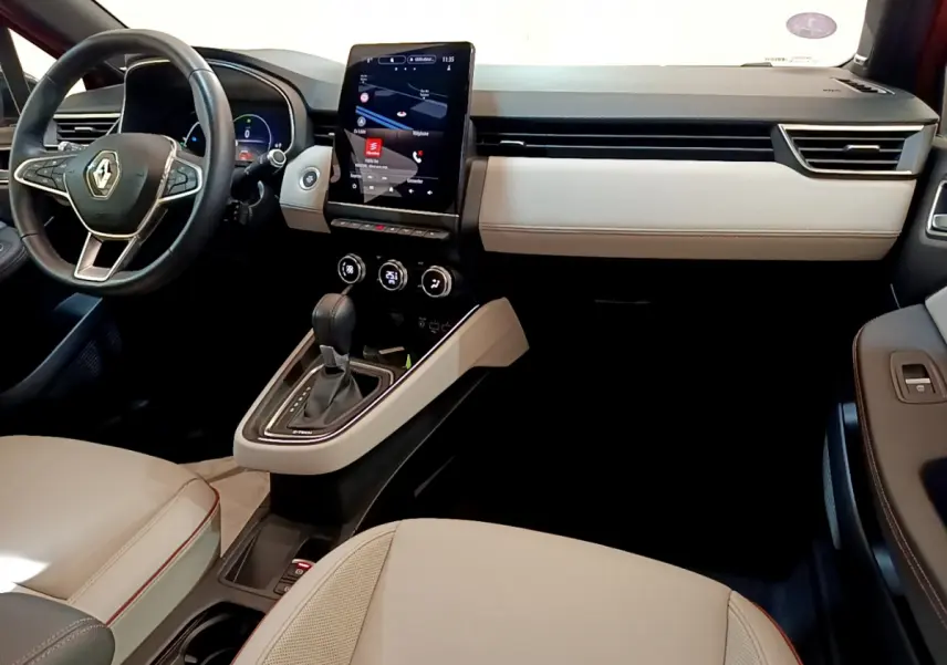 Intérieur clair de Renault Clio Initiale Paris 2021, vue côté conducteur avec écran tactile vertical et volant cuir noir.