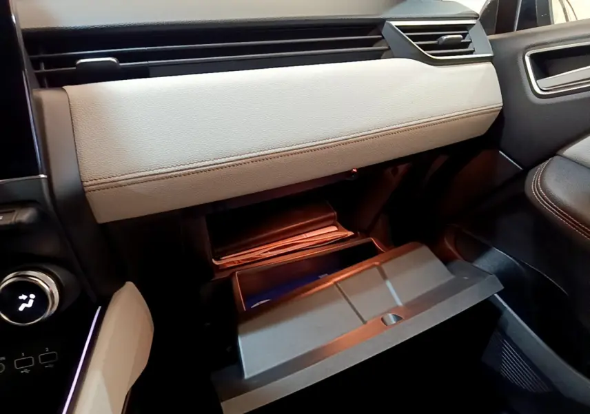 Gros plan sur la boîte à gants beige ouverte côté passager de la Renault Clio Initiale Paris orange 2021.