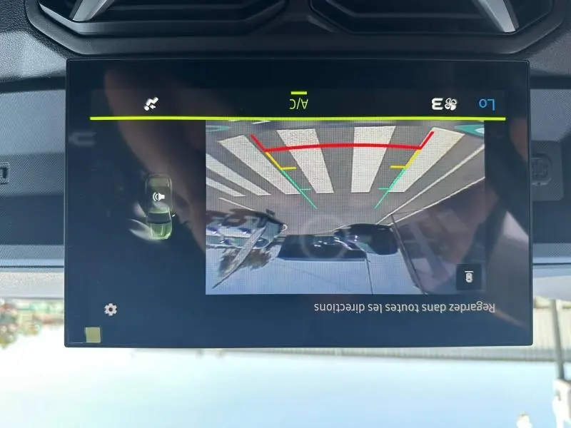 Écran tactile intérieur du Dacia Duster 2025 montrant la caméra de recul avec lignes de guidage colorées.