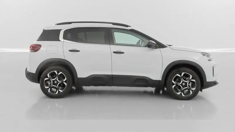 Profil droit d'un Citroën C5 Aircross hybride blanc avec toit noir et jantes distinctives en alliage.