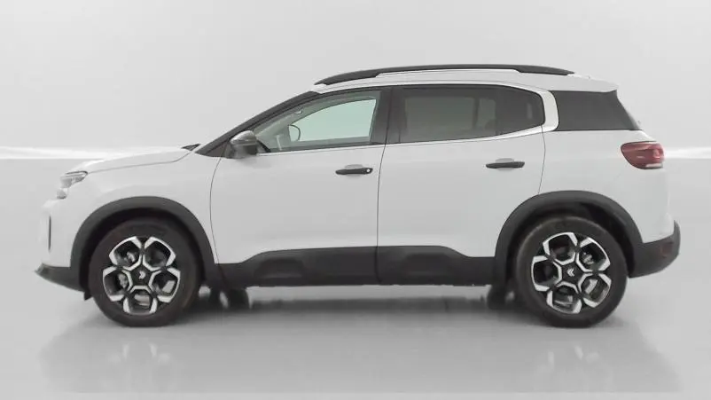 Vue de profil côté gauche du Citroën C5 Aircross hybride blanc avec jantes distinctives et toit noir contrasté.
