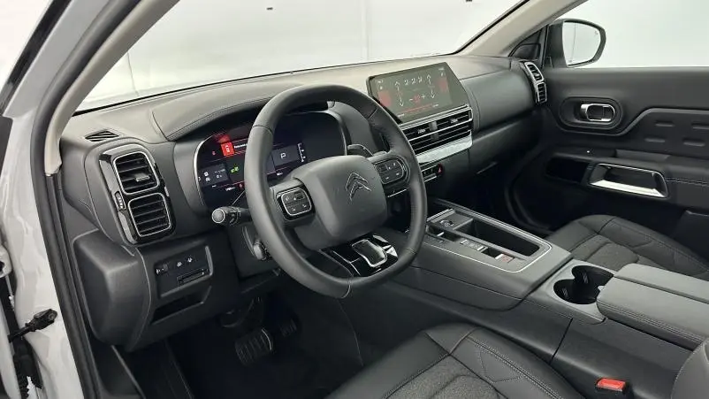 Vue intérieure côté conducteur du Citroën C5 Aircross blanc, volant cuir multifonctions et écran tactile central.