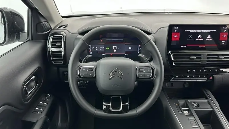 Vue intérieure centrée sur le volant cuir multifonctions du Citroën C5 Aircross Hybride avec écran tactile et combiné numérique.