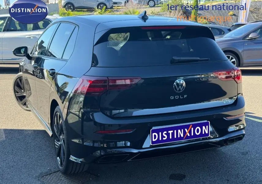 Vue 3/4 arrière droite d'une Volkswagen Golf 1.5 eTSI R-Line noire Grenadilla métallisée avec jantes alu noires.