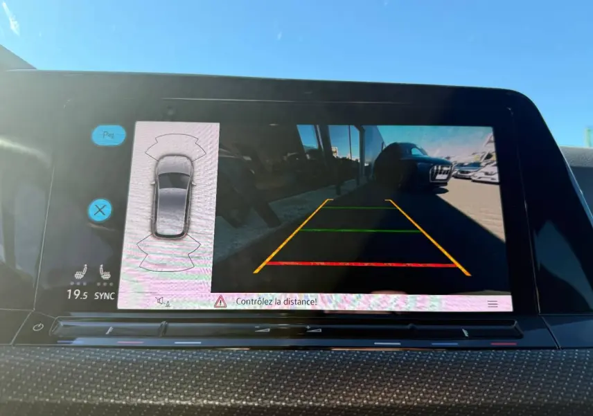 Écran tactile intérieur montrant la caméra de recul d'une Volkswagen Golf noir Grenadilla, vue arrière en stationnement.