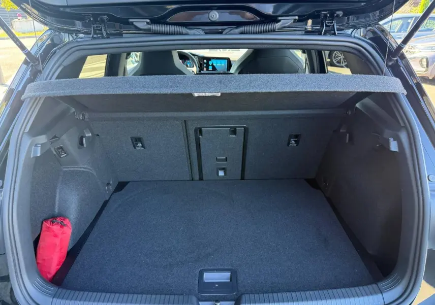 Coffre ouvert vu de l'arrière d'une Volkswagen Golf 1.5 eTSI noir Grenadilla, avec cache-bagages et intérieur gris.