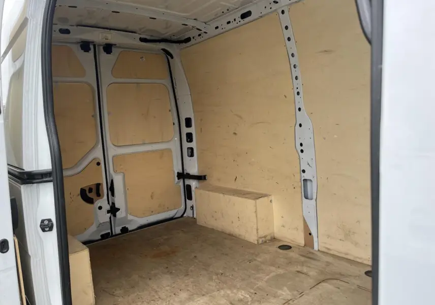 Vue intérieure arrière du Renault Master blanc 2022 avec aménagement bois complet et anneaux d'arrimage visibles.