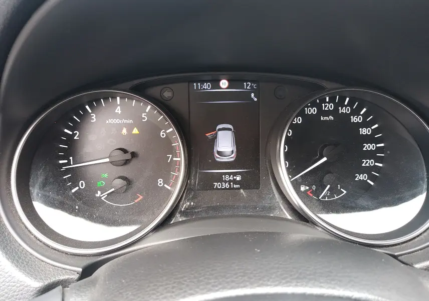 Vue rapprochée du tableau de bord du Nissan Qashqai blanc 2018, affichant compte-tours, vitesse et écran central.