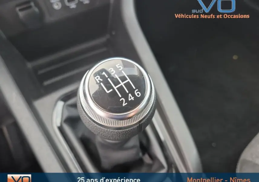 Gros plan sur le levier de vitesses manuel noir de la Renault Clio V TCe 90 Equilibre 2023, essence, intérieur sombre.