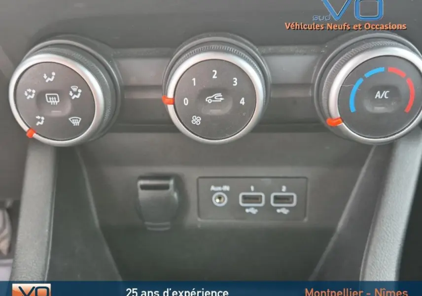 Gros plan sur les commandes de climatisation manuelle et les ports USB d'une Renault Clio V TCe 90 Equilibre noire de 2023.