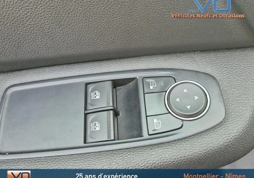 Gros plan sur les commandes de lève-vitres et rétroviseurs côté conducteur de la Renault Clio V TCe 90 noire 2023.