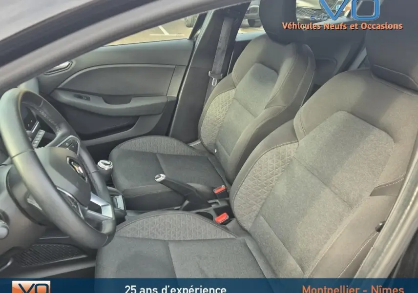 Intérieur de la Renault Clio V TCe 90 Equilibre 2023, vue côté gauche montrant sièges tissu gris et volant noir.
