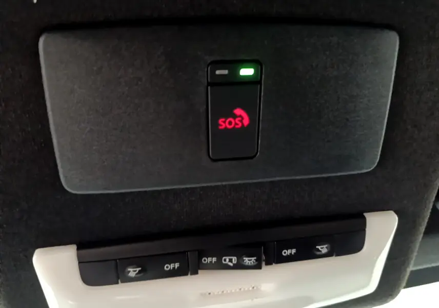 Détail du plafonnier noir avec bouton SOS rouge et commandes d'éclairage dans un Nissan Juke Hybrid gris foncé 2023.