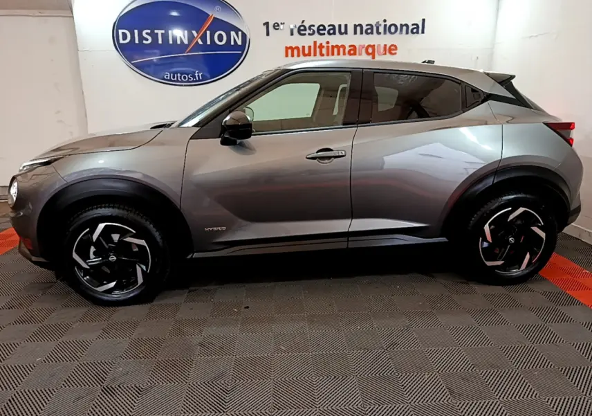 Profil droit du Nissan Juke Hybrid 143 Business+ gris foncé, avec jantes noires à motifs argentés.