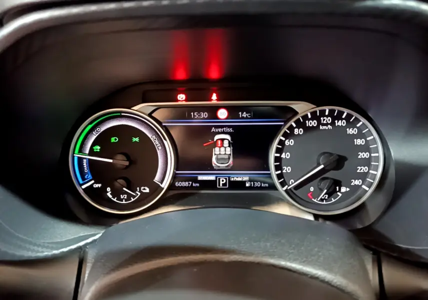 Gros plan sur le combiné d'instruments du Nissan Juke Hybrid 143 Business+, affichage digital et compteurs analogiques.