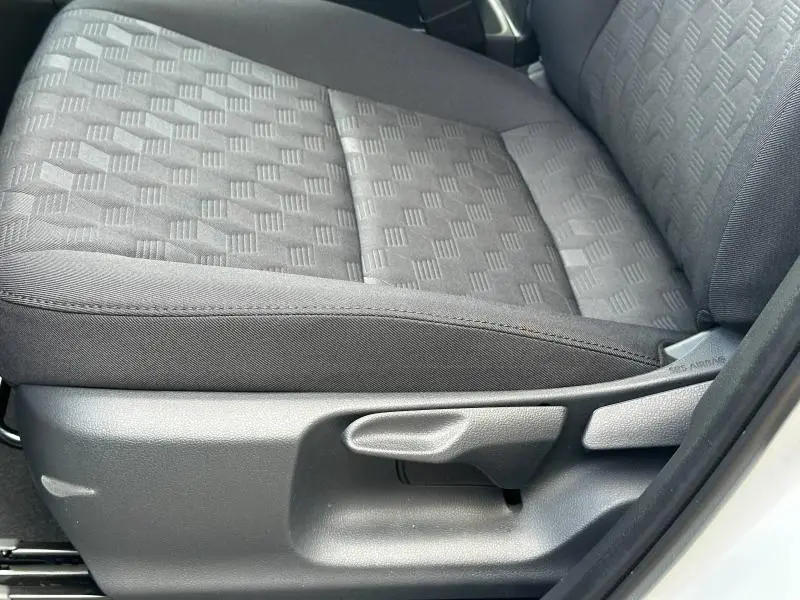 Gros plan sur l'assise avant droite noire à motifs géométriques du siège conducteur d'une Toyota Yaris blanche 2025.