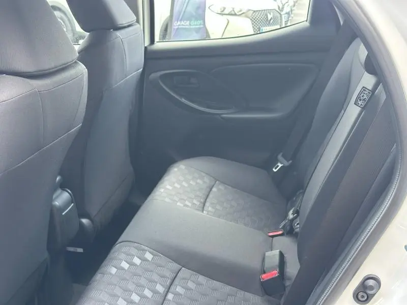 Vue intérieure arrière côté droit des sièges en tissu noir de la Toyota Yaris 116h Dynamic blanche 2025.