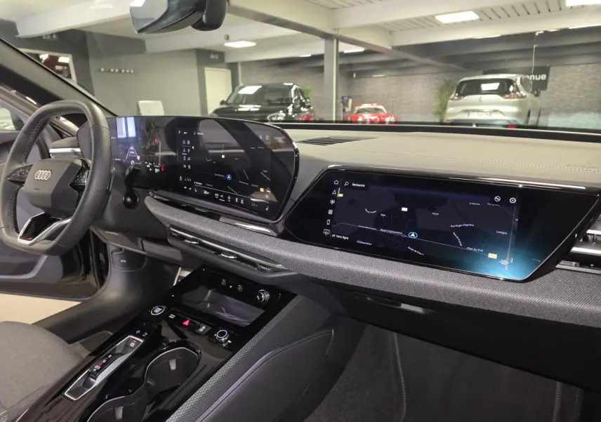 Vue intérieure côté conducteur de l'Audi A5 Avant 2025 noire, avec tableau de bord numérique et écran tactile central.