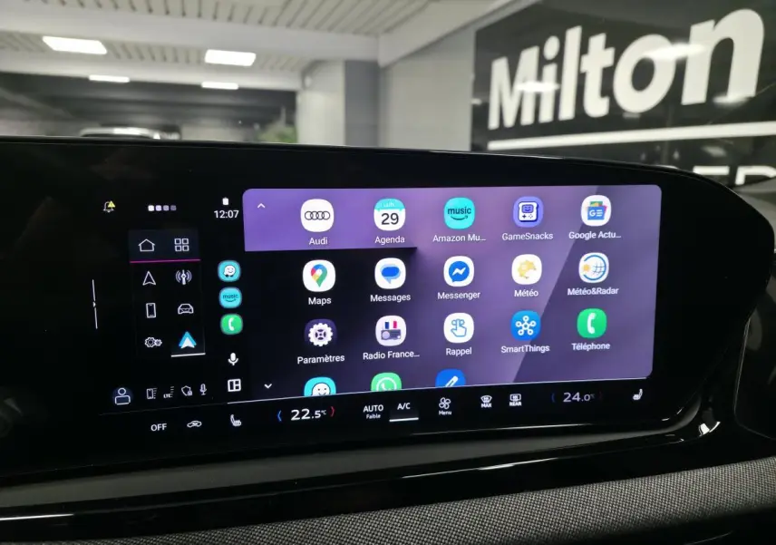 Écran tactile MMI central allumé dans l'habitacle de l'Audi A5 Avant noir, affichant plusieurs applications.