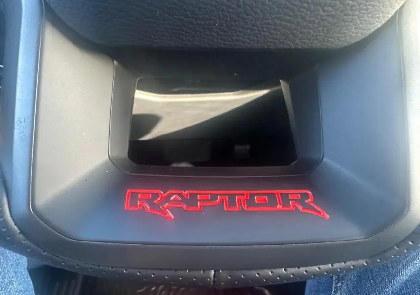 Gros plan sur le logo rouge RAPTOR sur la console centrale noire du Ford Ranger Double Cabine blanc.
