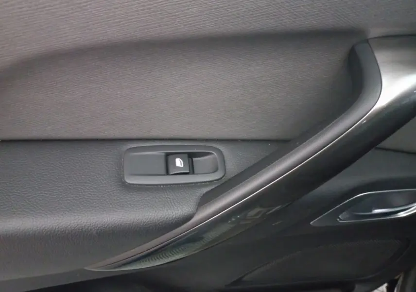 Gros plan sur la commande de lève-vitre côté porte intérieure noire du Citroën Grand C4 Spacetourer 2018.