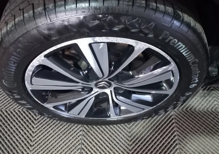 Gros plan sur la jante alliage noire et argentée avec logo Citroën au centre, pneu Continental PremiumContact 6 visible.