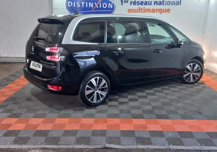 Vue 3/4 arrière gauche d'un Citroën Grand C4 Spacetourer noir avec toit contrastant blanc et jantes alliage.
