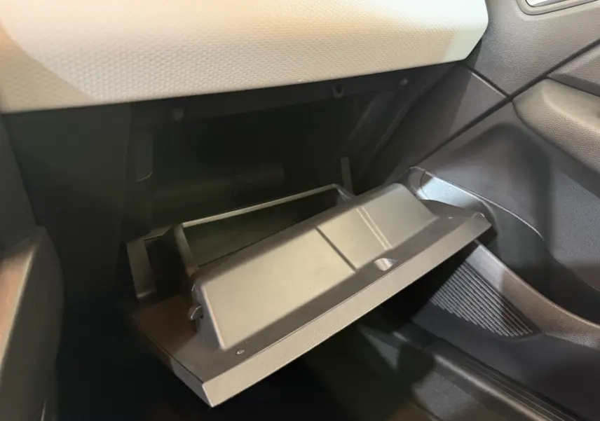 Gant de boîte ouverte côté passager intérieur de la Renault Clio Business blanc, montrant le rangement noir et la planche de bord claire.