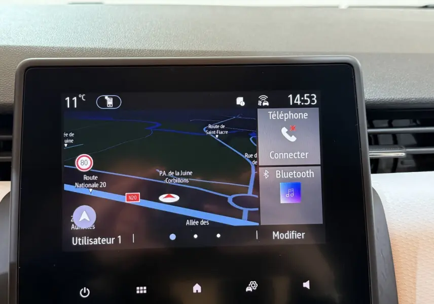 Écran tactile central de la Renault Clio Business blanc, affichant navigation 3D et options Bluetooth à l'avant.