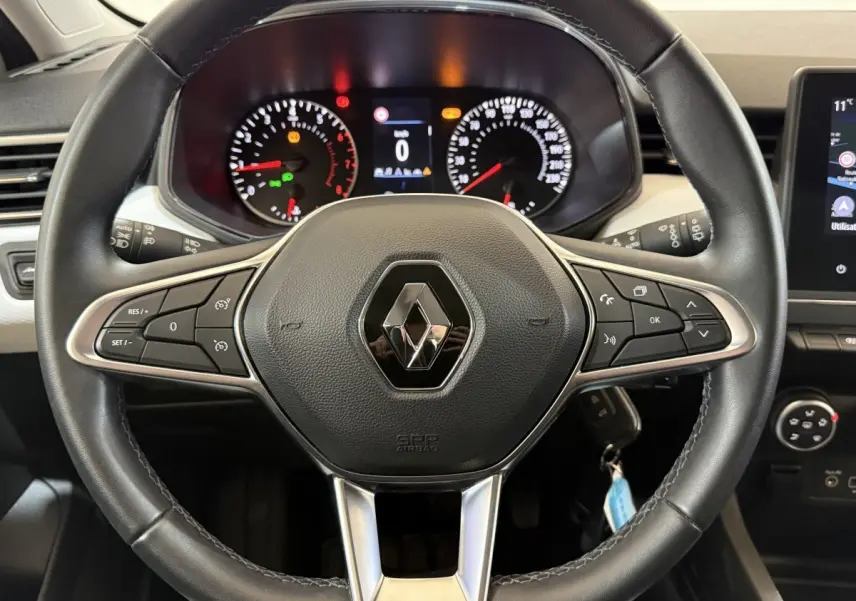 Vue rapprochée du volant cuir noir de la Renault Clio Business 2022 avec tableau de bord et commandes visibles.