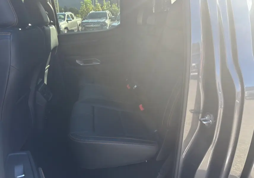 Vue intérieure côté gauche des sièges arrière en cuir noir avec surpiqûres orange du Ford Ranger Wildtrak gris carbone 2025.
