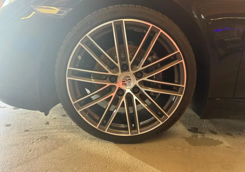 Gros plan sur la roue avant droite noire d’une Porsche 718 Boxster 2.0 300 de 2018 avec jante alliage multibranches.