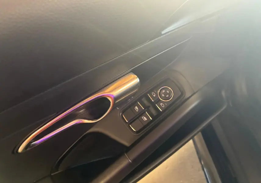 Poignée de porte intérieure côté gauche avec commandes électriques sur Porsche 718 Boxster noir, vue rapprochée.