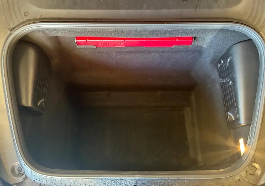 Vue plongeante sur le coffre avant noir vide du Porsche 718 Boxster 2.0 300 de 2018, avec éclairage intérieur.