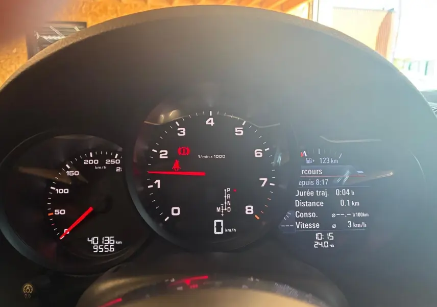 Vue rapprochée du tableau de bord noir de la Porsche 718 Boxster 2.0 300 de 2018 avec compte-tours et affichage digital.