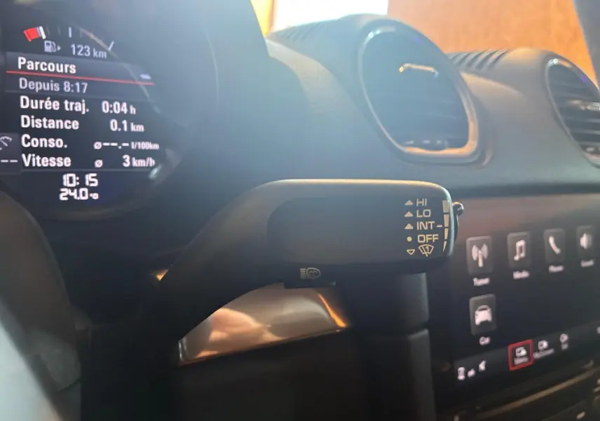 Gros plan sur le commodo d’essuie-glace à droite du volant dans l’habitacle noir d’une Porsche 718 Boxster 2018.