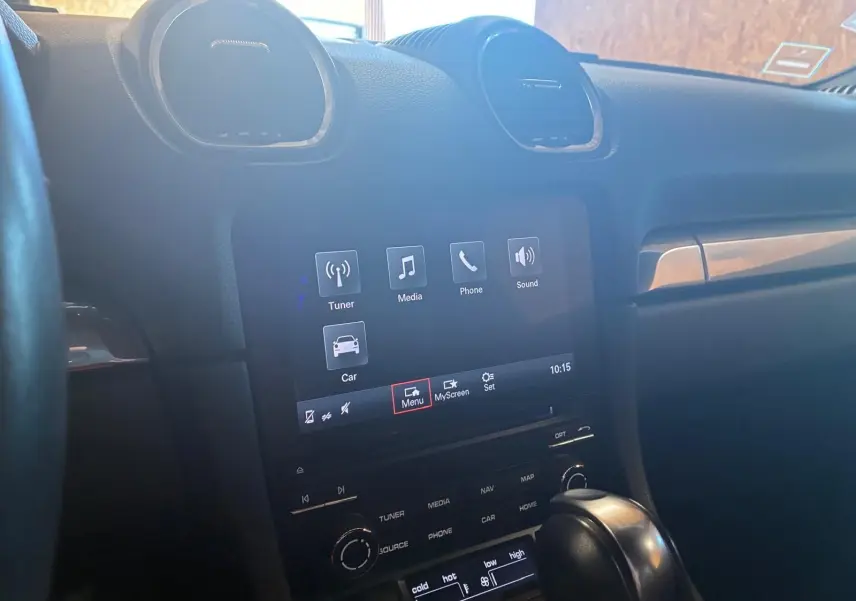 Vue intérieure centrée sur la console centrale tactile et le levier de vitesse d’une Porsche 718 Boxster noire de 2018.
